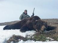 Happy hunter with his Russian Brown bear