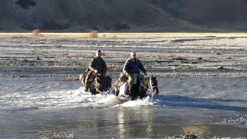 Crossing the river on horseback in Kyrgyzstan