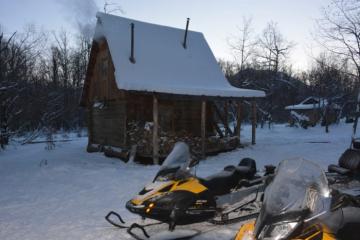 Snowmobiles in front of bear cabin